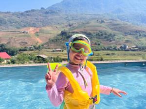 a young girl in a pool giving the peace sign at Lee Eco House Sapa in Sapa