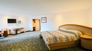 a hotel room with a bed and a desk at Hotel Altum Business in Toluca