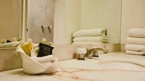 a bathroom with a sink and a mirror and towels at Hotel Altum Business in Toluca