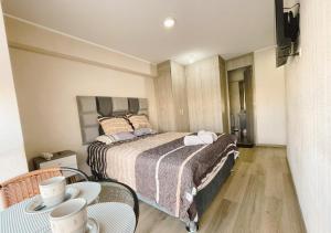 a bedroom with a bed and a table with chairs at Apacible y acogedora habitación con vista a Barranco in Lima