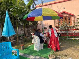 two women standing under a colorful umbrella at Kolkata Sarkar Villa Homestay in Kolkata