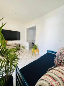 a living room with a bed and a flat screen tv at Espaço Familiar com Piscina in São Luís
