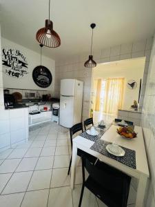 a kitchen with a table and chairs and a refrigerator at Espaço Familiar com Piscina in São Luís