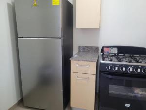 a kitchen with a refrigerator and a stove at Los Senderos in San Juan Opico