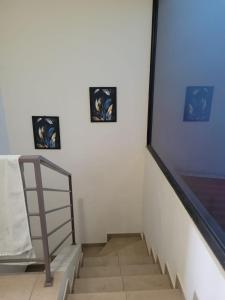 a staircase with three pictures on the wall and a ladder at Los Senderos in San Juan Opico