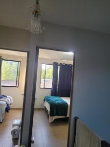 a bedroom with a mirror and a bed and a window at Los Senderos in San Juan Opico