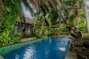 a swimming pool in front of a villa at Dukuh Sebatu Villa Ubud in Tampaksiring