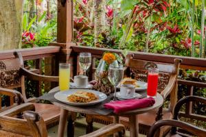 a table with plates of food and drinks on a patio at Dukuh Sebatu Villa Ubud in Tampaksiring