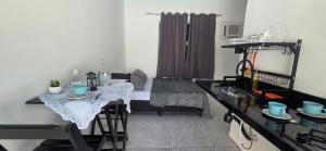 a living room with a table and a dining room at Arandu chalés maresias in São Sebastião