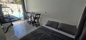 a bedroom with a bed and a table with chairs at Arandu chalés maresias in São Sebastião