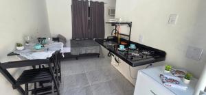 a kitchen with a counter and two tables in a room at Arandu chalés maresias in São Sebastião