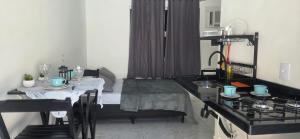 a living room with a table and a kitchen with a tableablish at Arandu chalés maresias in São Sebastião +1 photo