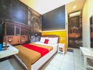 a bedroom with a bed with a train painting on the wall at RedDoorz @ Jalan Tanjung Blitar in Blitar