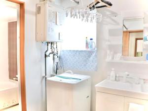 a white bathroom with a sink and a chandelier at Auberge Ninguruforet in Biei +39 photos