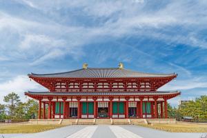 a red building with a roof in a park at Private House KANADE in Nara