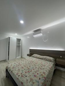 a bedroom with a bed with a floral bedspread at YOJU aparthotel in Colón