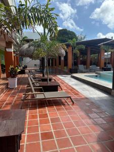 a resort with a pool and a patio with palm trees at Curasita Colour Appartments & Resort - adres kaya Sucre nst 282 in Willemstad
