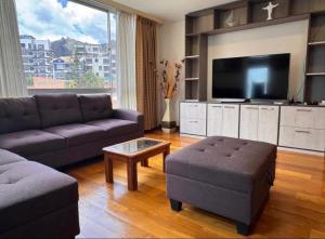 a living room with a couch and a flat screen tv at Salma in cuzco apart in Cusco
