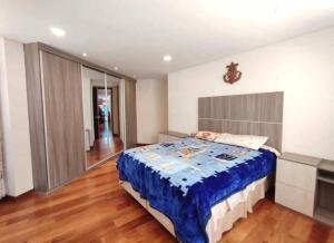 a bedroom with a bed with a blue comforter at Salma in cuzco apart in Cusco
