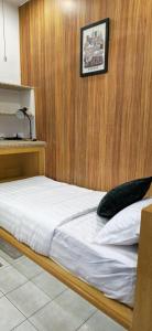 a bed in a room with a wooden wall at #MyPawsomeGetaway, Fun Family Retreat, Tanah Rata, Cameron Highlands in Tanah Rata