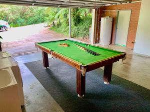 a pool table with cuesticks on top of it at Pacific Vista in Coffs Harbour
