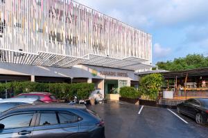 a car parked in a parking lot in front of a building at Xanadu Hotel Utapao in Rayong