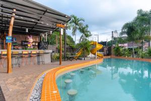 a swimming pool with a slide next to a resort at Xanadu Hotel Utapao in Rayong