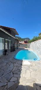 a swimming pool in front of a house at Arandu chalés maresias in São Sebastião
