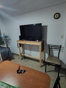 a living room with a television and a table with a chair at DepartamentoJAP in Venado Tuerto