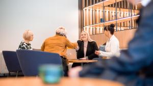 a group of people sitting around a table in a meeting at Courtyard Tampere City in Tampere