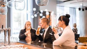 a group of people drinking at a bar at Courtyard Tampere City in Tampere