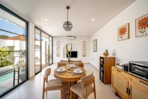 a kitchen and living room with a table and chairs at Maui Bingin Villas in Uluwatu