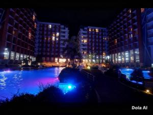 a large pool of water in a city at night at Prime World District Condo in Pajak +2 photos