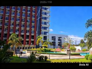 a view of a large apartment building with palm trees at Prime World District Condo in Pajak