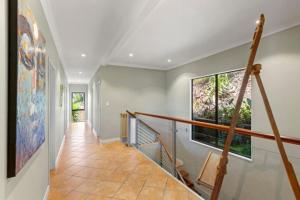 a hallway of a home with a staircase and two windows at Seasidestyle in Raglan