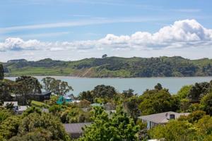a view of a lake with houses and trees at Seasidestyle in Raglan