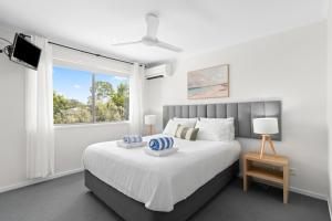 a bedroom with a large bed and a window at Direct Collective - Breeze on Brightwater in Mooloolaba +28 photos