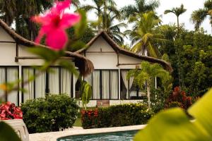 a house with a pink flower in front of it at Coral De Fuego Isla Fuerte in Puerto Limón