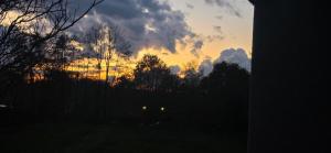 a sunset with trees and clouds in the sky at Noclegi Pracownicze Niepołomice in Niepołomice