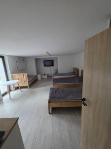 a room with two beds and a tv in it at Noclegi Pracownicze Niepołomice in Niepołomice