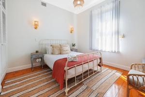 a bedroom with a bed with a red blanket at Morrissey Cottage in Warrnambool