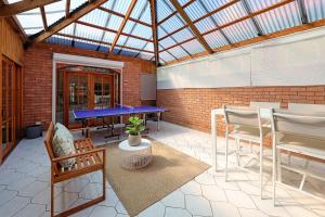 a conservatory with a ping pong table and chairs at Morrissey Cottage in Warrnambool