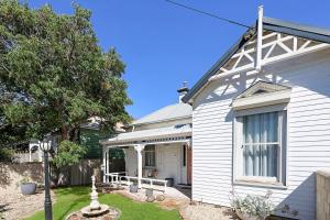 a white house with a window on the side of it at Morrissey Cottage in Warrnambool