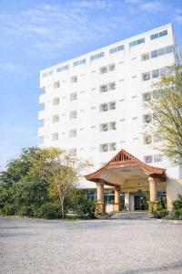 ein großes weißes Gebäude vor einem Gebäude in der Unterkunft Khamsrithongchai hotel in Mukdahan