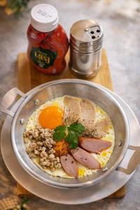 Eine Pfanne mit Eiern, Wurst und Brot stand auf einem Tisch. in der Unterkunft Khamsrithongchai hotel in Mukdahan + 4 Fotos