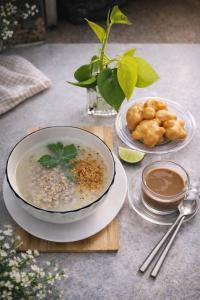 ein Tisch mit einer Schüssel Suppe und einem Teller Essen in der Unterkunft Khamsrithongchai hotel in Mukdahan