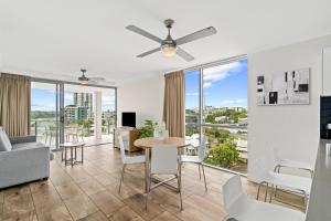 a living room with a table and chairs and glass windows at Direct Collective - Pavilion and Governor on Brookes in Brisbane