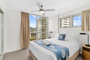 a bedroom with a bed and a large window at Direct Collective - Pavilion and Governor on Brookes in Brisbane