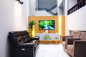 a living room with a couch and a tv at Hotel Cafe Boutique in Pereira
