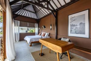 a bedroom with a bed and a desk in a room at Nami House Balian in Balian